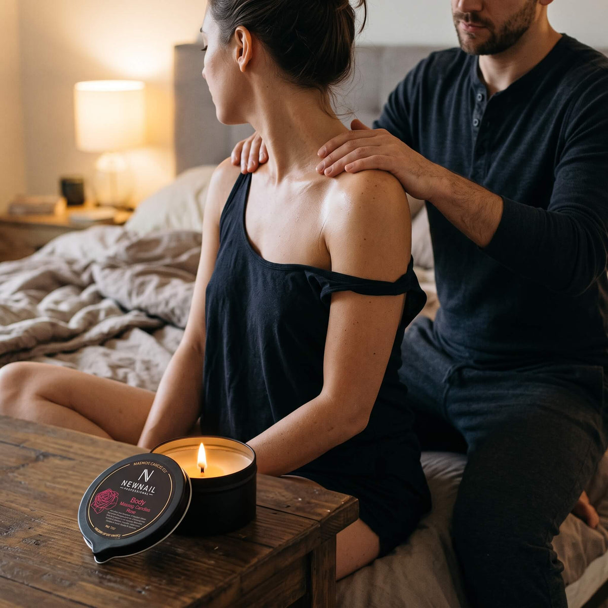 Couple next to a lit massage candle during a shoulder massage