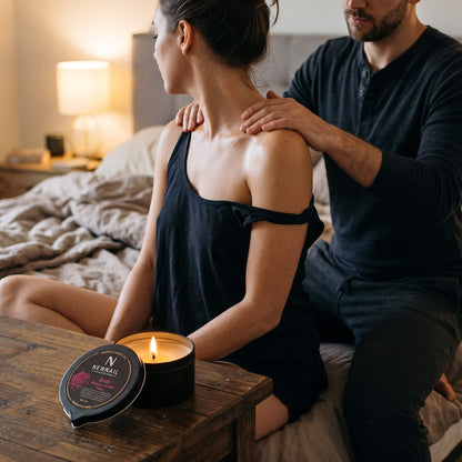 Couple next to a lit massage candle during a shoulder massage